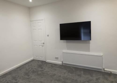 a white room with a flat screen tv on the wall at 81b Queens Road in Watford