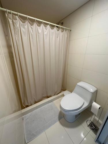 a bathroom with a toilet and a shower curtain at Altamira Surubi-i in Estancia Sarubi