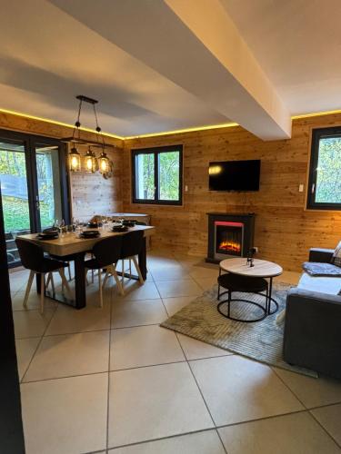 a living room with a dining table and a fireplace at Appartement cosy entre lacs et montagnes in Guillestre