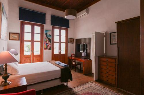 une chambre avec un lit, un bureau et une table dans l'établissement Villa St Teresa do Porto: HarboursideVilla-SeaViews-Pool-BBQ-StarLink-6Bedrm, à Rio de Janeiro