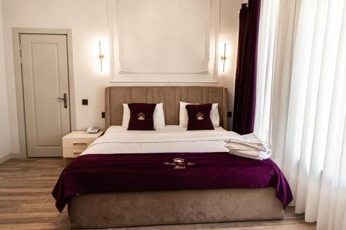 a bedroom with a large bed with purple sheets and pillows at Perla De Mar Hotel & Restaurant in Baku