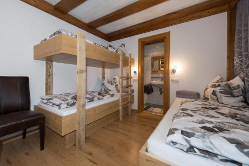 a bedroom with two bunk beds and a chair at Angelas Appart in Ehrwald