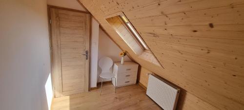 a small room with a toilet in a wooden wall at Kotwica in Jezierzany