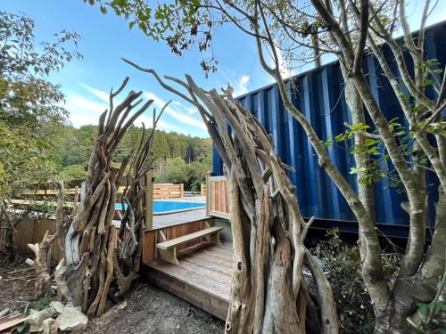 a house made out of trees and a wooden deck at Nakadaki Art Village in Isumi