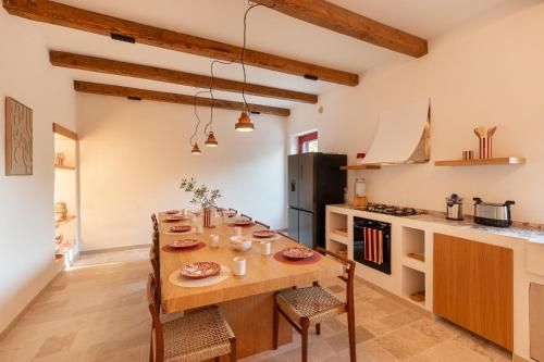 Una cocina con una mesa de madera en una habitación. en Trulli D'Amore - Itria Valley Exclusive Trulli Villa, en Santa Lucia