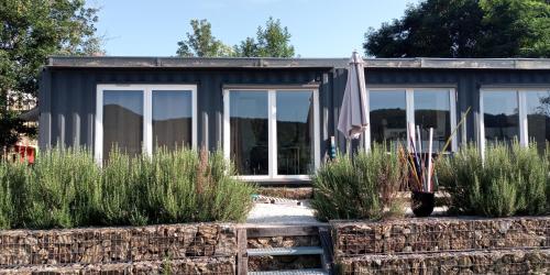 a small house with windows and plants in front of it at Maison-containers en Nord-Ardèche in Saint-Félicien