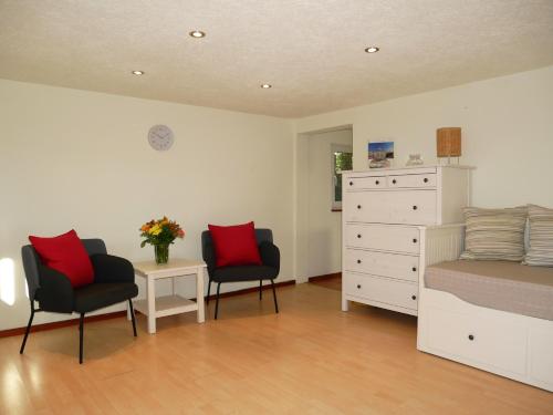 - une chambre avec un lit, deux chaises et une commode dans l'établissement kleiner Holzbungalow Grundmann mit Naturgarten, à Wilhelmsfelde