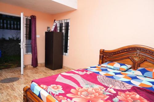 a bedroom with a bed with a colorful comforter at December Holiday inn 1 Bedroom House with 2 tent houses in Kodaikānāl