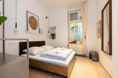 a bedroom with a bed with white sheets and a window at Berlin & Friends in Berlin