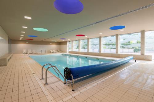 a swimming pool with a blue slide in a building at Premium Flat w/ Pool, Gym & Garage by HostWise in Vila Nova de Gaia
