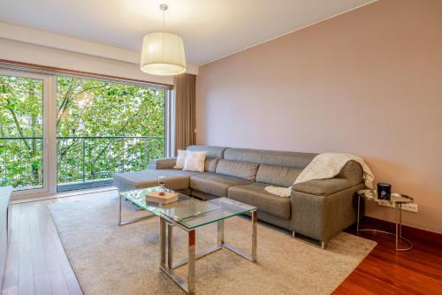 MassarelosにあるPremium Flat w/ Pool, Gym & Garage by HostWiseのソファとガラスのテーブルのあるリビングルーム