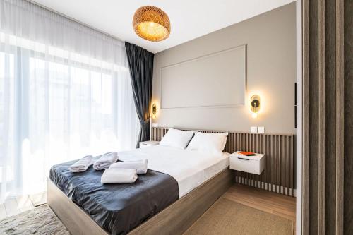 une chambre avec un lit et une grande fenêtre dans l'établissement Spacious 2BR Apartment - with Balcony and View, à Vatra Mînăstirii Cotroceni