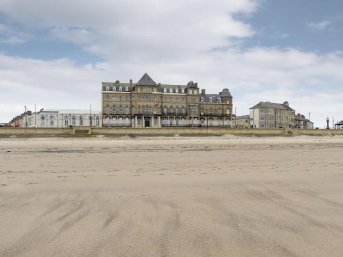 - un grand bâtiment au sommet d'une plage de sable dans l'établissement Sea View Penthouse - Regency Mansion, à Redcar