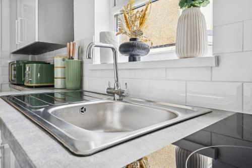 a stainless steel sink in a kitchen with a window at Clover House Stunning Cosy Cottage 3BR By AltoLuxo Short Lets & Serviced Accommodation With Free WiFi & Parking in Ebbw Vale
