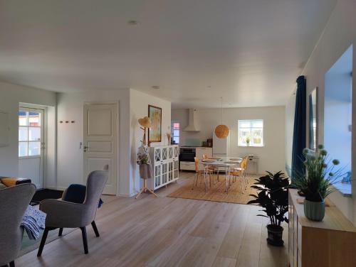 a living room with a kitchen and a dining room at Luxury retreat with direct access to nature in Bøtø By