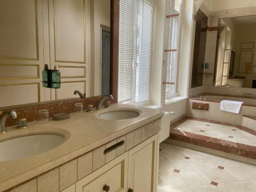 a bathroom with two sinks and a large mirror at Château de Flixecourt in Flixecourt