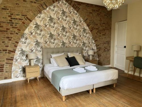 a bedroom with a large bed with a brick wall at Château de Flixecourt in Flixecourt
