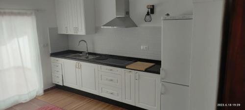 a kitchen with white cabinets and a sink at Malaka in Coín