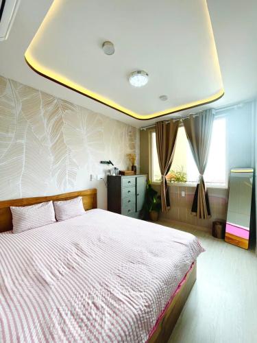 a bedroom with a large bed with a ceiling at 49homestay in Ấp Khánh Phước (1)