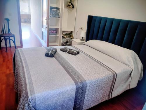 a bedroom with a bed with a blue headboard at Apartamento Rural La Manchega in Villar del Arzobispo