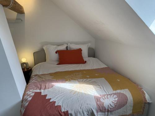 a small bedroom with a bed with a red pillow at Domaine à la Loëx in Geneva