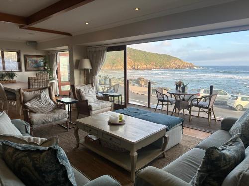 een woonkamer met uitzicht op de oceaan bij Woelwaters Beach Villa in Herolds Bay