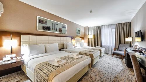 伊斯坦布尔肯特酒店的一间带两张床和一张书桌的大酒店房间