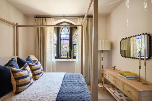a bedroom with a canopy bed and a stained glass window at Luxury Cotswolds Retreat nr Estelle Manor 