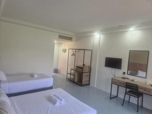 een kamer met 2 bedden en een bureau met een televisie bij USAS Resort, Kuala Kangsar in Kuala Kangsar