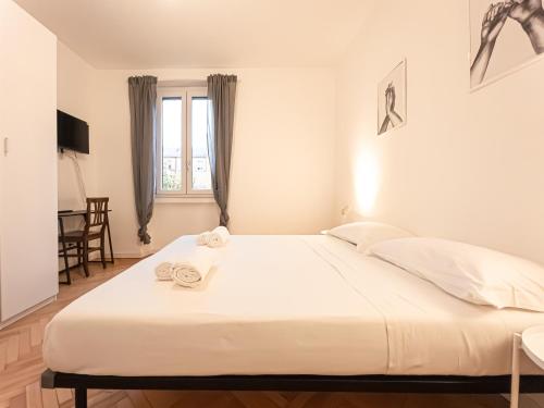 a large white bed in a room with a window at RRRapido Sant' Ambrogio Suites and Rooms - Via Olona in Milan