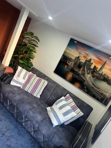 a living room with a couch and a painting on the wall at Luxury 1 Bedroom Back House In Lakeside in West Thurrock