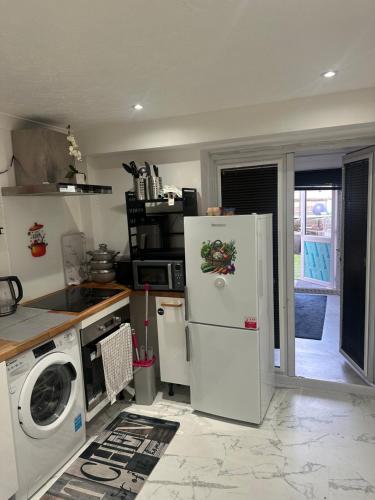 a kitchen with a refrigerator and a washing machine at Luxury 1 Bedroom Back House In Lakeside in West Thurrock