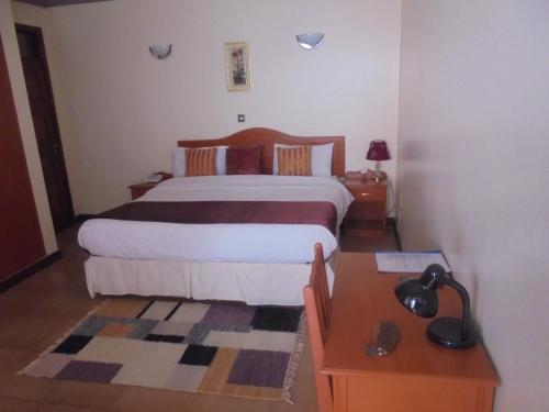 a bedroom with a large bed and a table at Villa Leone Boutique Hotel in Nairobi