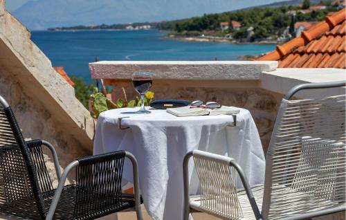 スティヴァンにあるBeautiful Home In Sutivanのバルコニーにテーブルとワイン1杯