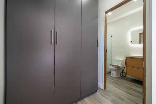 a bathroom with a toilet and a large closet at Sunset Garden 16 - Eco Design Villa with Private Pool near Nai Harn Beach in Rawai Beach