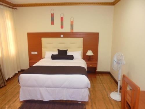 a bedroom with a large bed and a fan at Villa Leone Boutique Hotel in Nairobi
