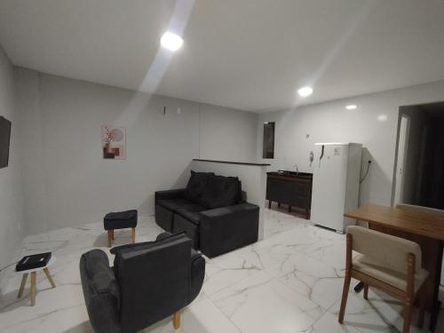 a living room with a couch and a kitchen at Apart Hotel São Pedro Inn Caxias sup in Santa Cruz da Serra