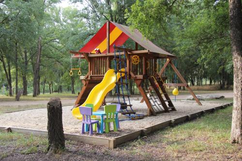 un parque infantil con tobogán y sillas en Almond Cabin en Fredericksburg