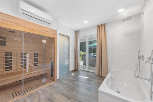 a bathroom with a tub and a shower and a sink at House Martina in Labin