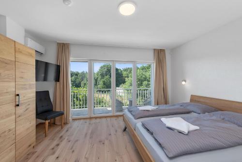 a bedroom with two beds and a television and a balcony at House Martina in Labin