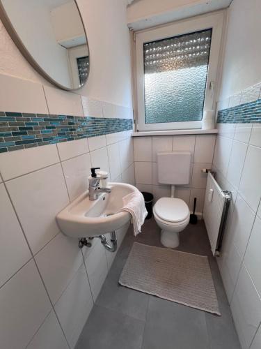 a bathroom with a sink and a toilet and a mirror at Ferienwohnung Rheinglück in Oppenheim