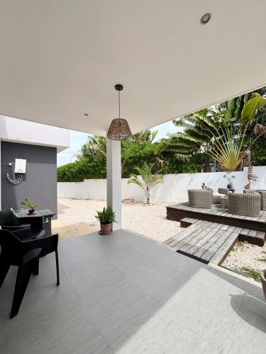 a patio with a table and a bench and a table and chairs at Sunset Ocean View in Jan Thiel