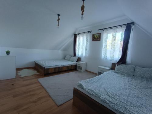 a bedroom with two beds and two windows at Casa Fresh in Sântimbru-Băi