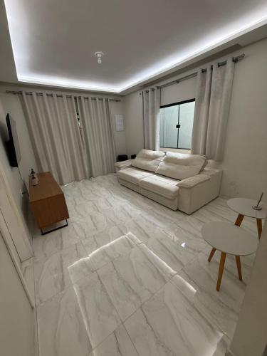 a large living room with a couch and a window at Casa de 4 Quartos - 2 suites in Ananindeua