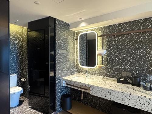 Un baño con lavabo, inodoro y espejo. en Shō Hotel BreakX, en George Town