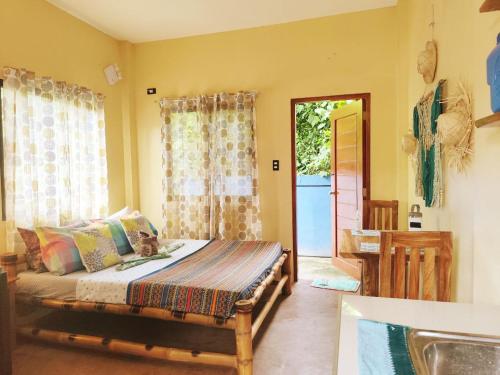 a bedroom with a bed and a door to a yard at Amwani Azure in Puerto Princesa City