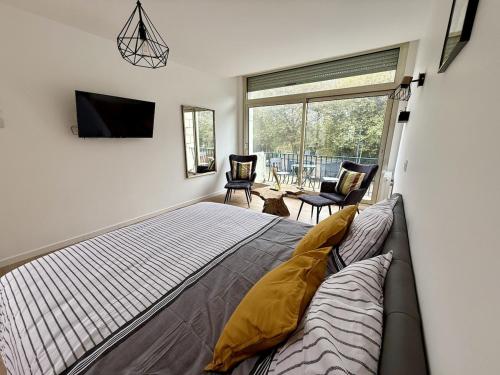 a bedroom with a bed and a large window at Le Calais Wilson 7 - Studio Balneo 2p in Calais