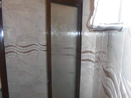 a shower with a glass door in a bathroom at Villa Leone Boutique Hotel in Nairobi