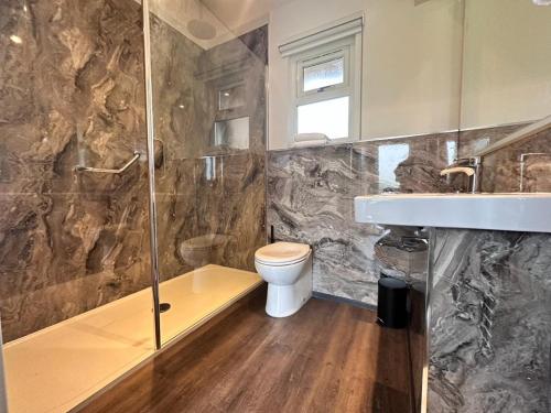 a bathroom with a toilet and a sink and a shower at Sea Marge Seaview Lodges in Overstrand