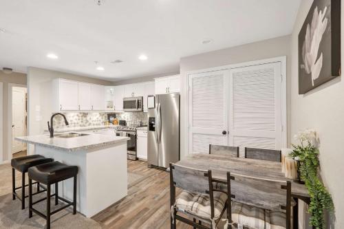 a kitchen with white cabinets and a kitchen island with bar stools at Restful Retreat - 2BDR for 6 in Kimberling City